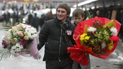 Men give flowers to women for International Women's Day